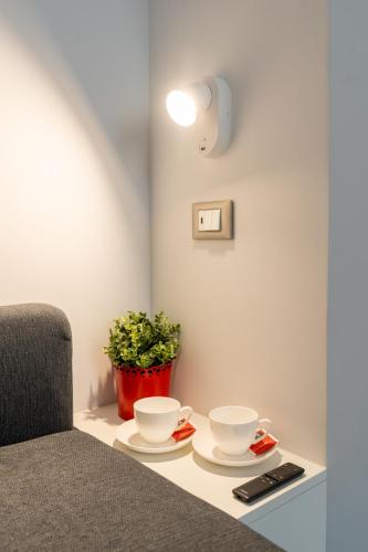 a table with two cups and a potted plant at Damatti Appartamento in Messina