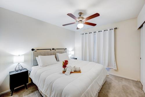 a bedroom with a large white bed with a ceiling fan at Chic Vegas Retreat: Near Top Attractions in Las Vegas