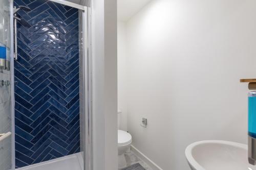 a bathroom with a shower and a toilet and a sink at Ocean Apartments in Littlehampton