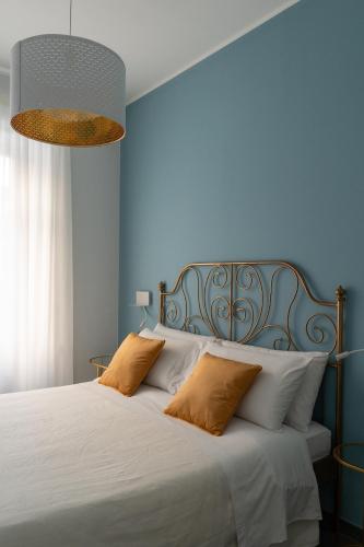 a blue bedroom with a bed with two pillows at Damatti Appartamento in Messina