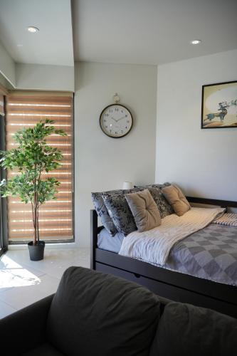 una camera con un letto e un orologio a muro di Dominiks Elegant Apt Ocean Views, Pool at Tambuli Resort 10 Floor a Maribago