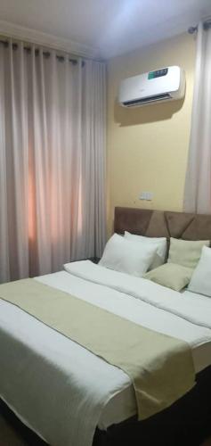two beds in a bedroom with a window and a heater at Benji Apartments in Jiru