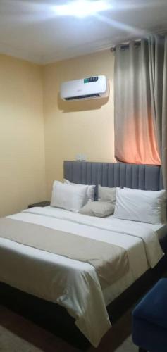 a bedroom with a large white bed with a window at Benji Apartments in Jiru