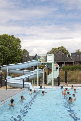 - un groupe de personnes dans une piscine avec toboggan dans l'établissement Les lodges de Sainte-Suzanne, à Sainte-Suzanne