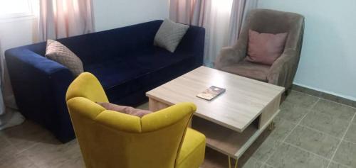 sala de estar con sofá, mesa y sillas en Benji Apartments en Jiru