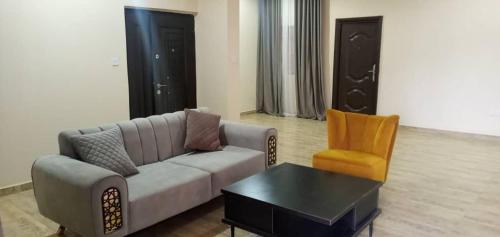 uma sala de estar com um sofá e uma cadeira em Benji Apartments em Jiru