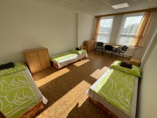 a room with two beds and a table with chairs at D8 APARTMÁNY in Ústí nad Labem