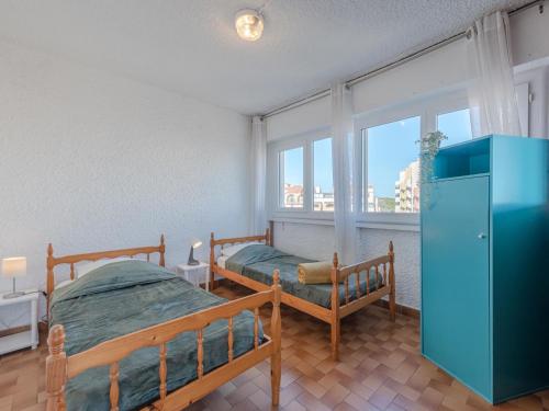 ポール・ルカートにあるApartment Les Cyclades-2 by Interhomeのベッドルーム1室(ベッド2台、青いキャビネット付)