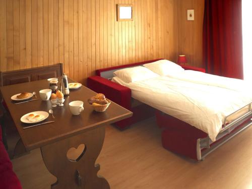 Un dormitorio con una cama y una mesa con comida. en Apartment Beausoleil 14 by Interhome, en Verbier