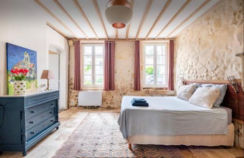 - une chambre avec un lit, une commode et des fenêtres dans l'établissement Grande maison en bord de rivière, à Cambes