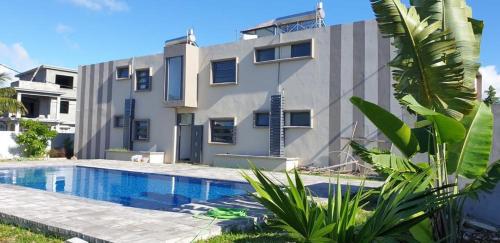 Centre de Flacq的住宿－ANILLAH APPARTMENTS，一座房子前面设有游泳池