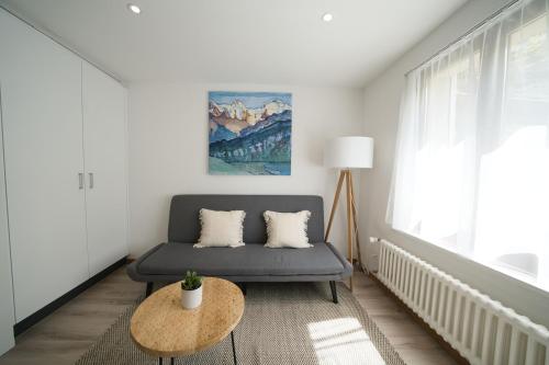 een woonkamer met een bank en een tafel bij Bijou Studio with Ambiance near Lake in Faulensee