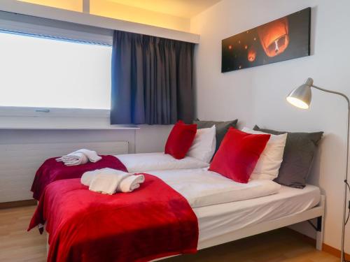 1 Schlafzimmer mit 2 Betten mit roten und weißen Decken in der Unterkunft Apartment Rosablanche C65 by Interhome in Siviez