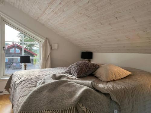 uma cama num quarto com uma grande janela em Alpstigen 6A - 10 bäddars fjällstuga mitt i Järvsöbacken em Järvsö