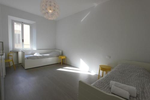 Camera bianca con 2 letti e un lampadario pendente. di SantAmbrogio Apartment a Firenze