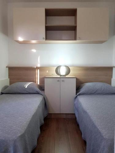 a bedroom with two beds and a white cabinet at Beautiful private house 50m from the sea in Kali