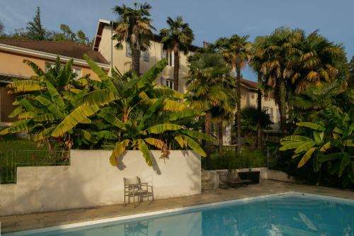 a pool in front of a house with palm trees at Maison Tournesol in Gan