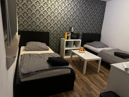 a room with two beds and a small table at Fair apartment 2 in Kelsterbach