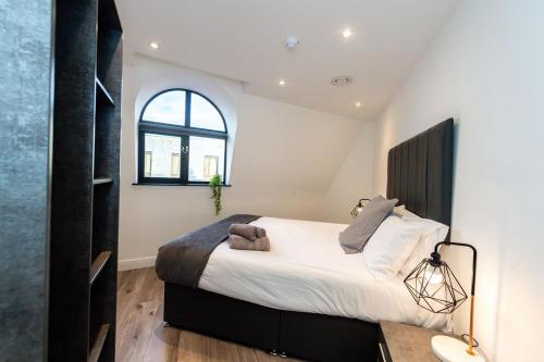 a bedroom with a large bed and a window at Two Bedroom Duplex in Liverpool City Centre in Liverpool