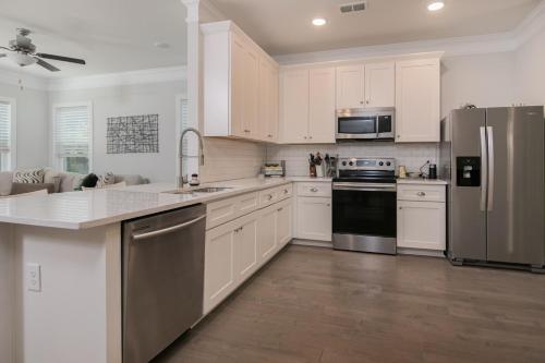 a kitchen with white cabinets and stainless steel appliances at Lowcountry Lux 5 min to Beach 7 min to Dtwn in Charleston