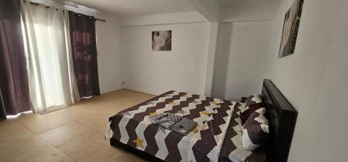 a bedroom with a bed with a blanket on it at Lovely 3-Bed Villa in Goodlands Mauritius in Goodlands
