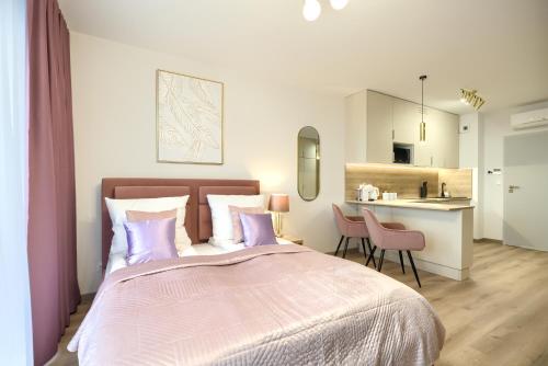 a bedroom with a large bed and a kitchen at AboutArtApartments - Otyńska 4 in Wrocław