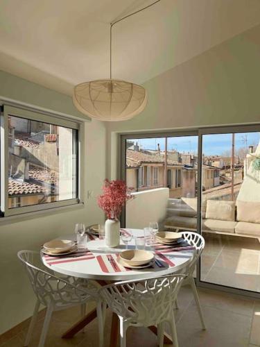 une salle à manger avec une table et des chaises et une fenêtre dans l'établissement Magnifique appartement + terrasse au cœur d’Aix, à Aix-en-Provence