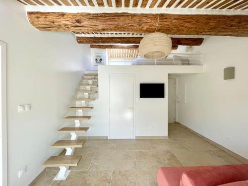 a spiral staircase in a room with a couch at Magnifique appartement + terrasse au cœur d’Aix in Aix-en-Provence