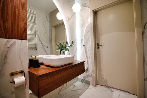 a bathroom with a white sink on a wooden counter at Apartamenty Laguna Beskidów - B35 in Zarzecze