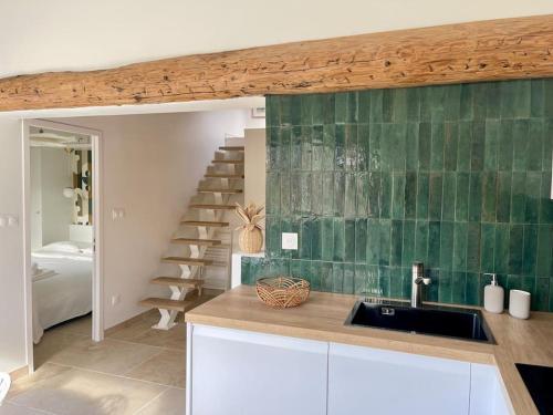 a kitchen with a sink and a green tile wall at Magnifique appartement + terrasse au cœur d’Aix in Aix-en-Provence