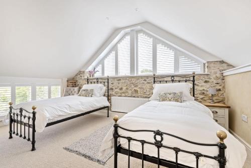 two beds in a bedroom with a large window at Yawlings in Holditch