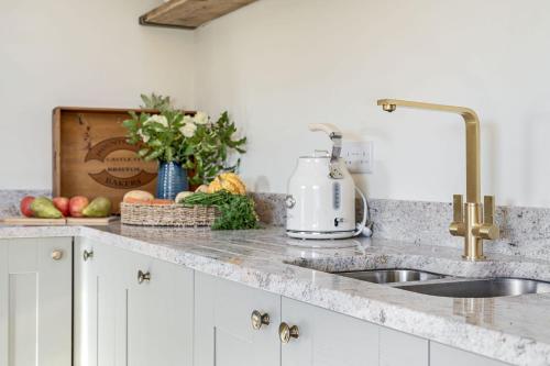 a kitchen counter with a sink and fruits and vegetables at Yawlings in Holditch