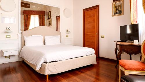 1 dormitorio con 1 cama blanca y TV en Cà Doge, en Venecia