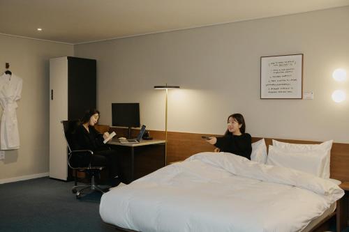 two women in a hotel room with a bed at Aank Hotel Suwon in Suwon