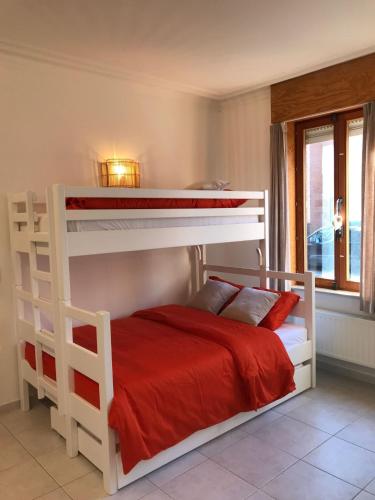a bedroom with two bunk beds with red sheets at Maison Nausikaa in Ostend