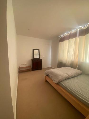 een slaapkamer met een bed, een dressoir en een spiegel bij Luxury double room in Nottingham