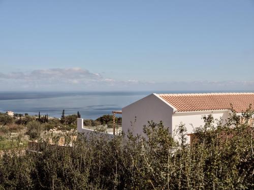 a white house with a view of the ocean at Ocean Luxury Villas in Volimes