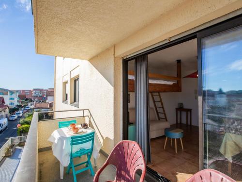 Habitación con balcón con mesa y cama. en Apartment Le Grand Large by Interhome, en Capbreton