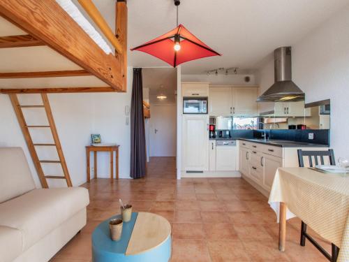 eine Küche und ein Wohnzimmer mit einer Couch und einem Tisch in der Unterkunft Apartment Le Grand Large by Interhome in Capbreton