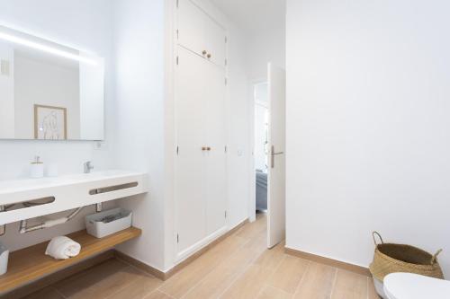 W białej łazience znajduje się umywalka i lustro. w obiekcie Home2Book Stylish & Luminous Apt Santa Cruz Center w mieście Santa Cruz de Tenerife