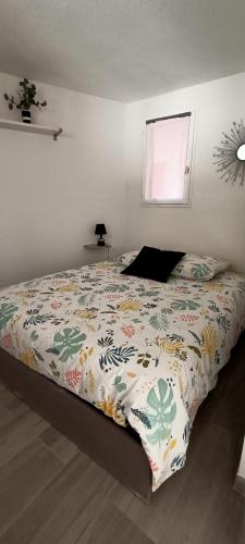 une chambre avec un lit avec une couette et une fenêtre dans l'établissement Port Cogolin, T2 calme dans belle résidence, piscine, proche St Tropez, à Cogolin