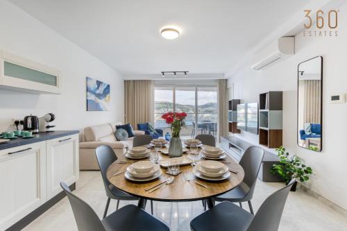 a dining room and living room with a table and chairs at Waterfront 3BR home, with private balcony by 360 Estates in St. Paul's Bay