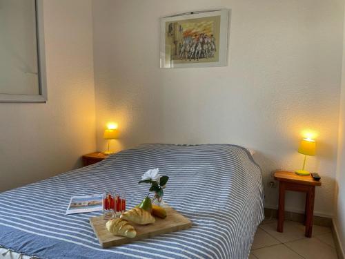 - une chambre avec un lit et un plateau de nourriture dans l'établissement Apartment Les Saladelles-4 by Interhome, au Grau-du-Roi