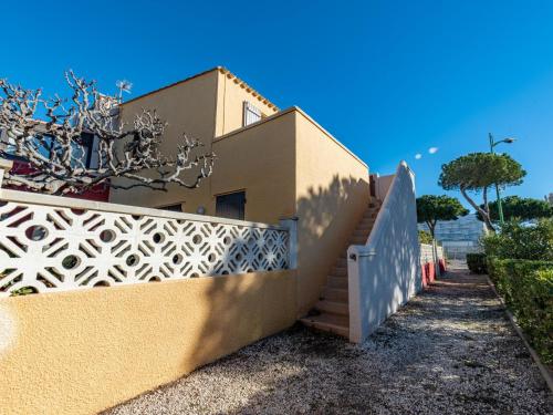 a house with a fence and a staircase at Apartment Les Caraïbes du Levant by Interhome in Le Barcarès