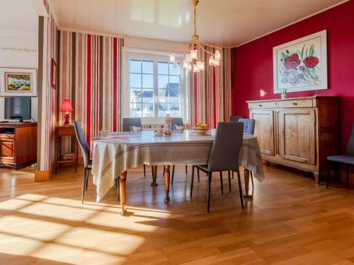 une salle à manger avec des murs rouges, une table et des chaises dans l'établissement Apartment Le Normandie Home by Interhome, à Cabourg