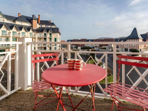 a red table with two cups on a balcony at Apartment Le Manoir by Interhome in Cabourg