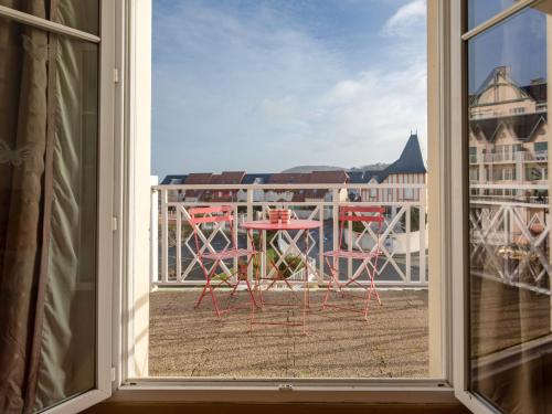 Habitación con vistas a un balcón con mesa y sillas. en Apartment Le Manoir by Interhome, en Cabourg