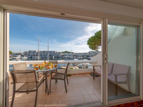 a balcony with a table and chairs and a view at Apartment Les Régates by Interhome in Le Grau-du-Roi
