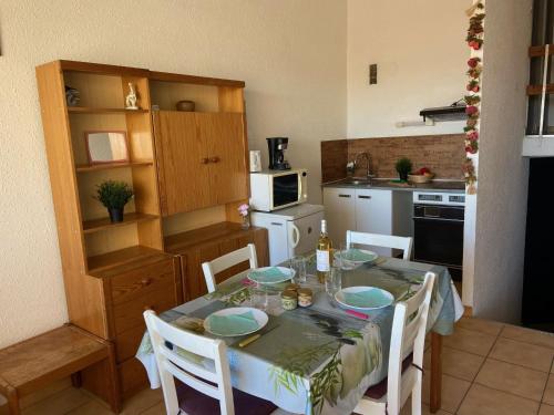 a kitchen with a table with chairs and a dining room at Apartment Les Saladelles-8 by Interhome in Le Grau-du-Roi