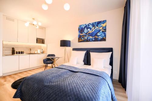 a bedroom with a bed with a blue blanket at AboutArtApartments - Otyńska 4 in Wrocław
